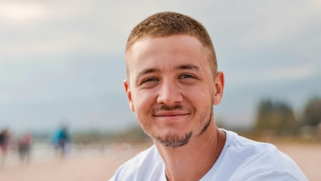 Smiling man in a white shirt outdoors after opting out of Advanced-People-Search