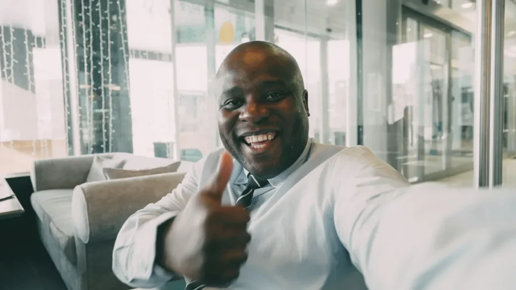 Smiling man in a suit giving a thumbs up after opting out of AllPeople