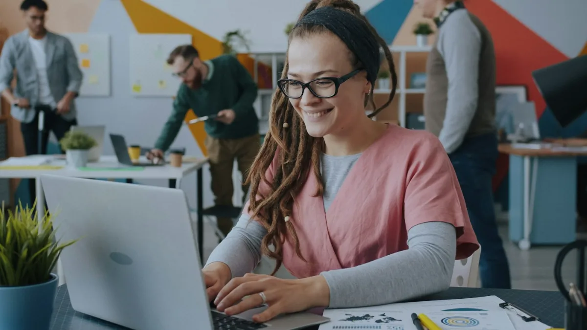 Business owner smiling at her laptop after a fake Google review was removed from her business profile