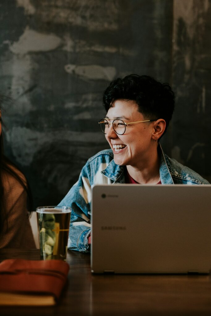 Smiling man laughing while using a laptop
