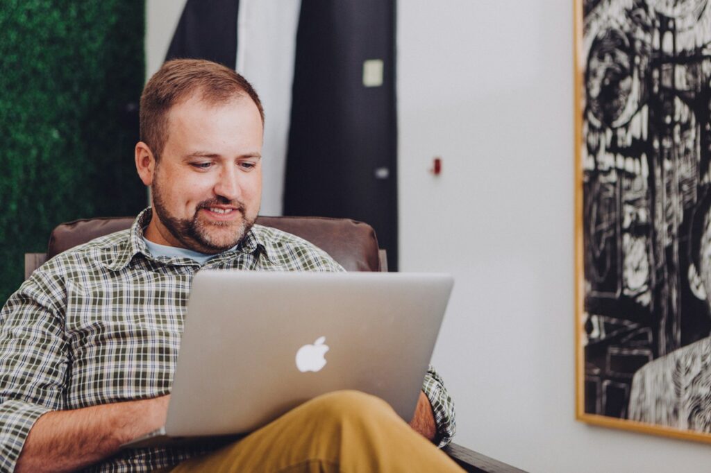 Smiling man working on a laptop