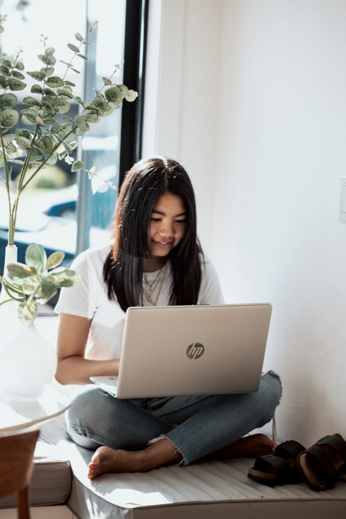 Smiling woman in a white shirt using a laptop