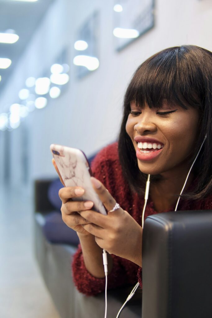 Smiling woman in a pink shirt holding a smartphone