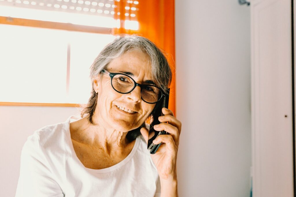 Smiling woman in glasses talking on the phone