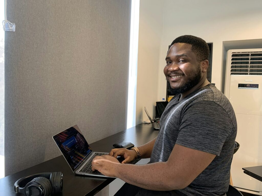 Smiling man sitting at a desk with a laptop