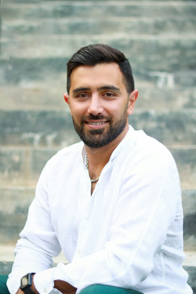 Smiling man with a beard sitting on steps