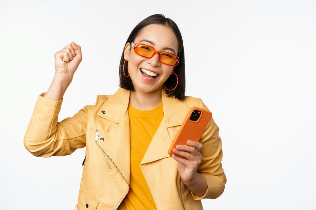 Smiling woman in a yellow jacket holding a phone