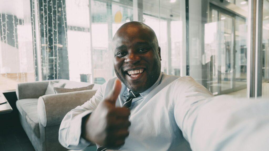 Smiling man in a suit giving a thumbs up