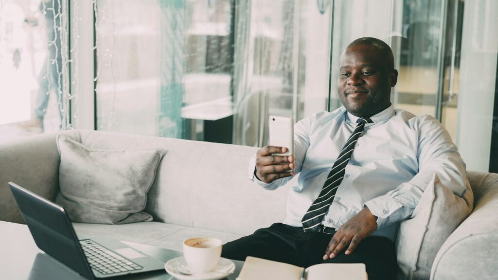 Smiling man in a shirt and tie looking at his phone
