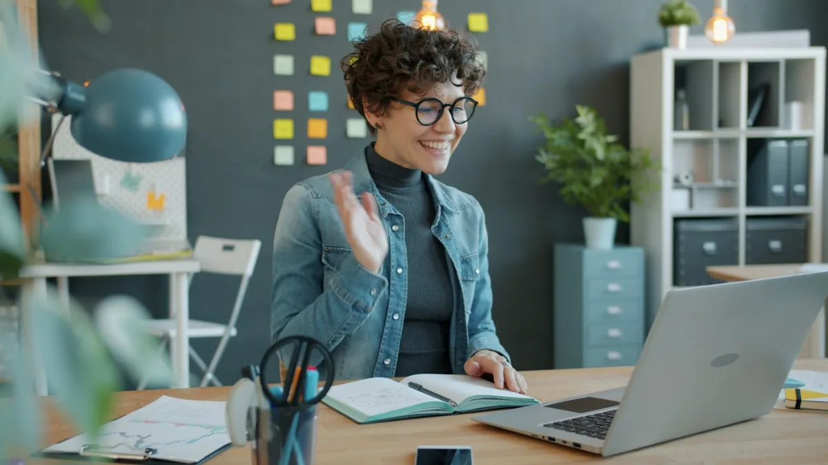 Woman smiling at her laptop after negative Google results about her were pushed off page one
