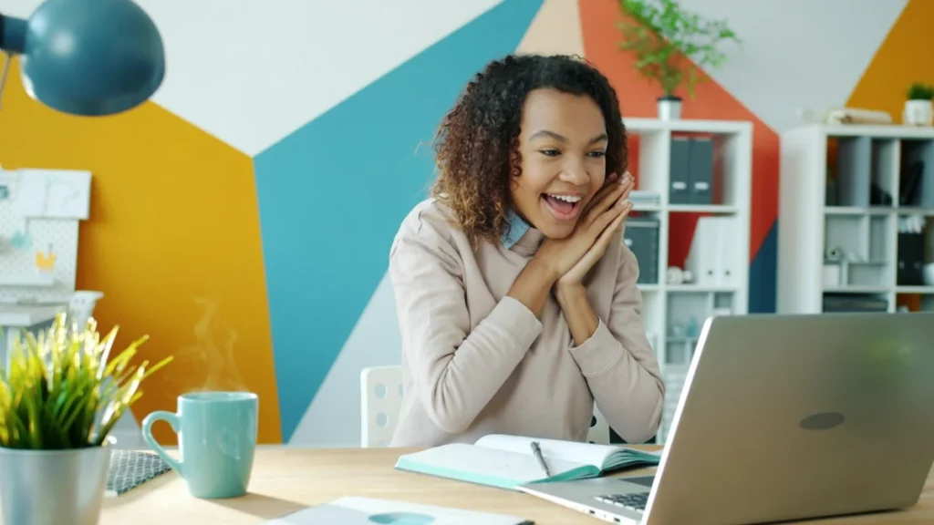 Smiling woman looking at her laptop after her case was removed from Google